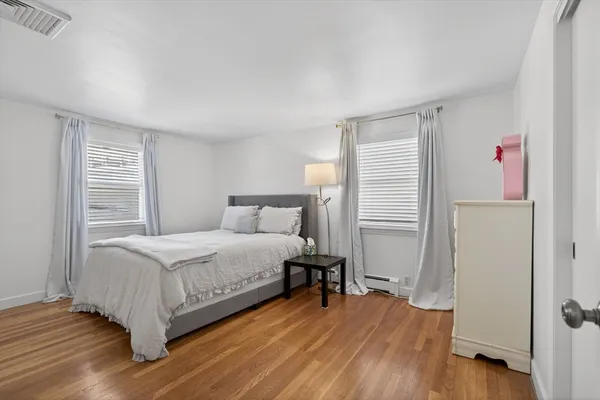 a bedroom with a bed and a wooden floor
