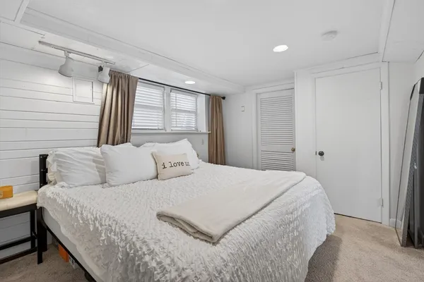 a bedroom with a large bed and a window