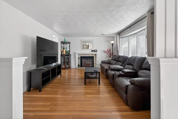 a living room with furniture a flat screen tv and a fireplace