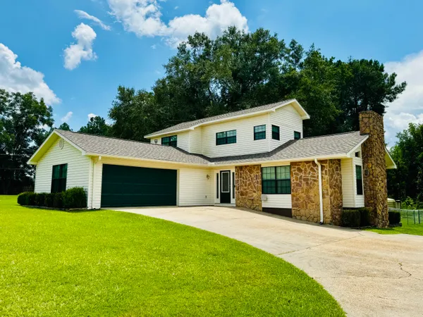 a front view of house with yard and green space