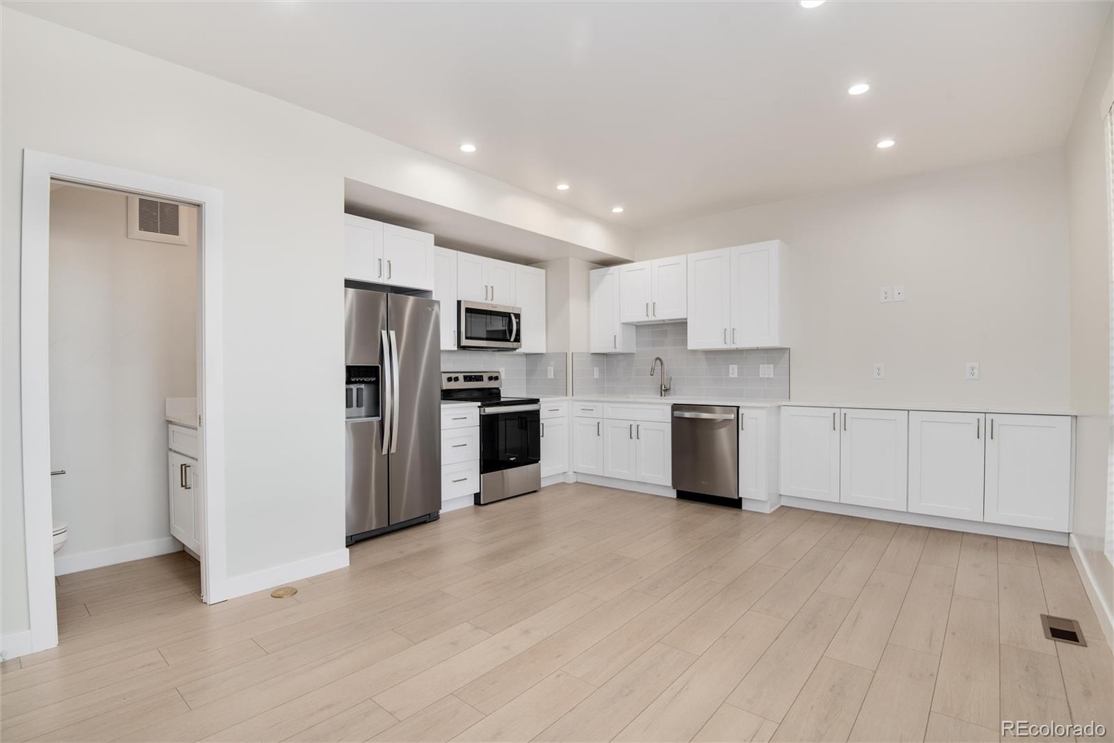 1395 Xavier Street, Unit 2 Denver, CO 80204 - Photo 2 of 14 a kitchen with white cabinets and stainless steel appliances