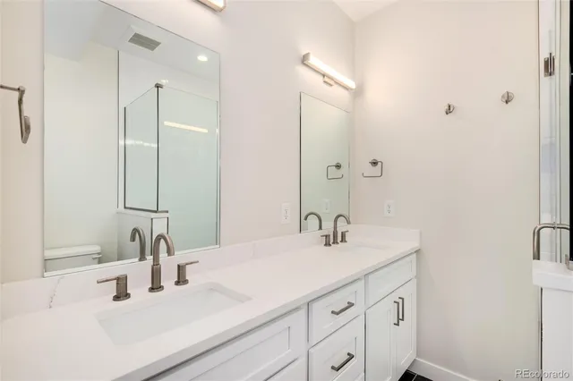 a bathroom with double vanity sink and a mirror