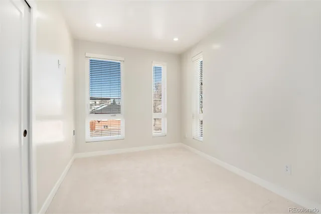 an empty room with windows and closet