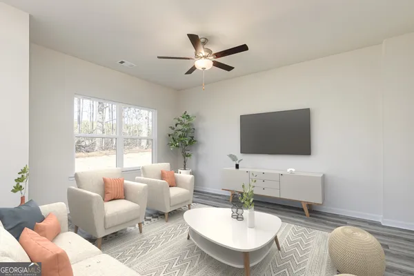 a living room with furniture a window and a flat screen tv