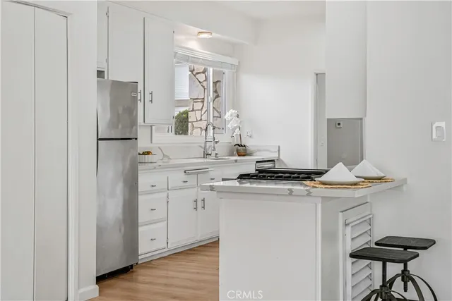 a kitchen with stainless steel appliances granite countertop a stove a refrigerator and a dining table