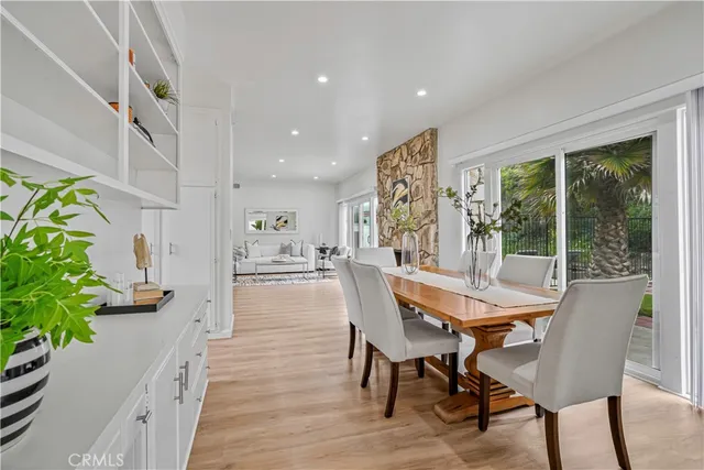 a dining room with furniture potted plants and wooden floor