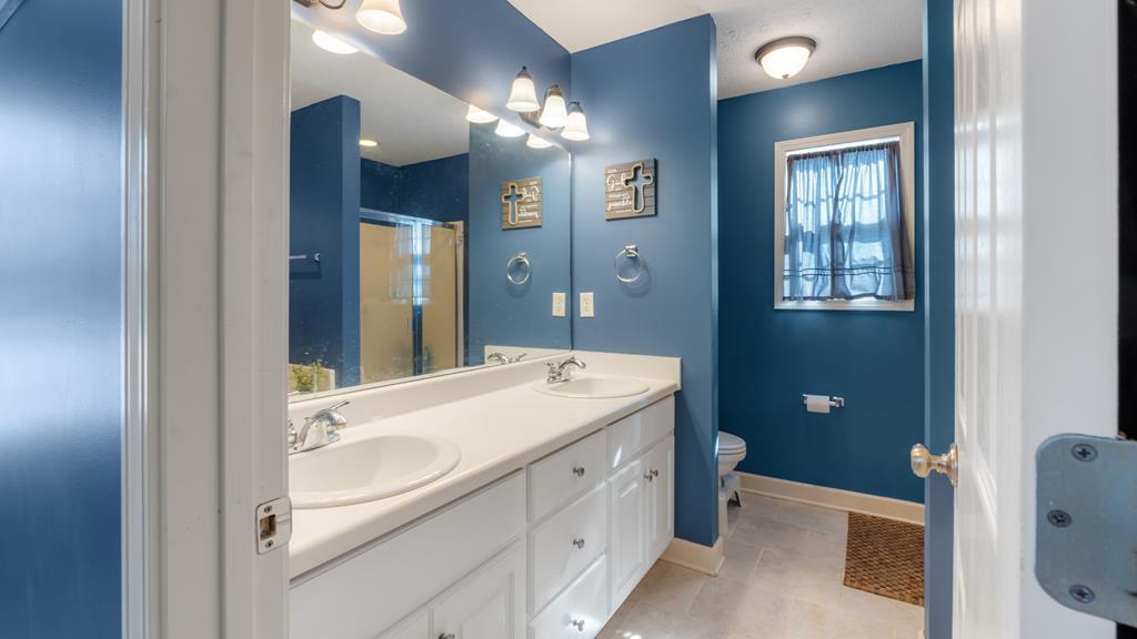 165 Firetower Road Buena Vista, GA 31803 - Photo 14 of 30 a spacious bathroom with a double vanity sink a toilet and a mirror