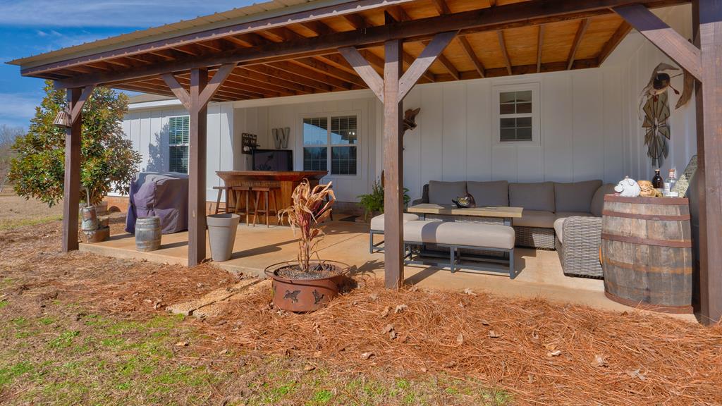 165 Firetower Road Buena Vista, GA 31803 - Photo 25 of 30 a backyard of a house with barbeque oven table and chairs