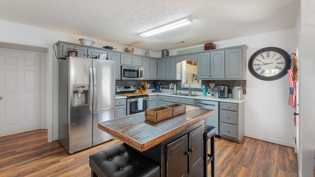 165 Firetower Road Buena Vista, GA 31803 - Photo 9 of 30 a kitchen with stainless steel appliances granite countertop a refrigerator a stove and a wooden floors
