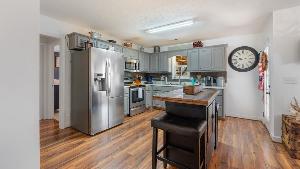 165 Firetower Road Buena Vista, GA 31803 - Photo 10 of 30 a kitchen with a refrigerator a stove and wooden floor