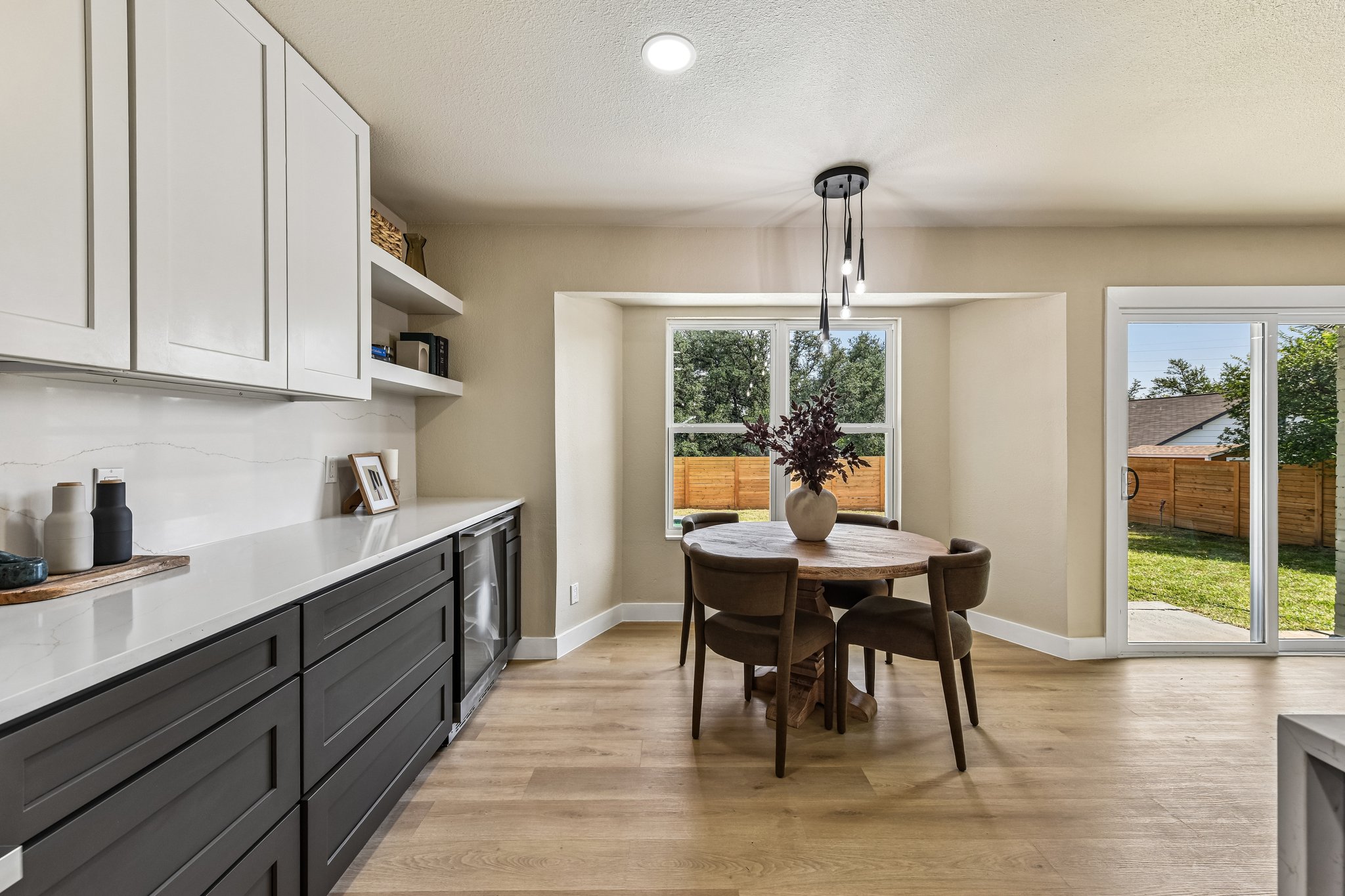 7523 Glenhill Road Austin, TX 78752 - Photo 12 of 38 A well-lit dining area featuring a circular table, modern light fixture, and convenient access to the outdoor space.