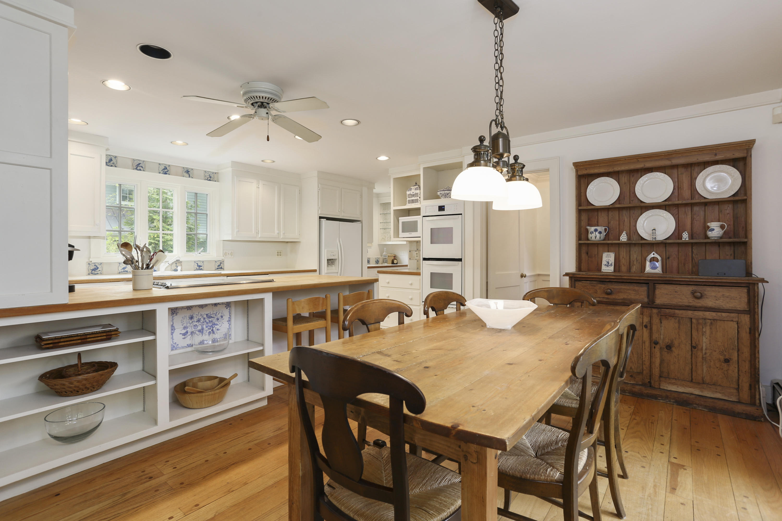 5 Meadowbrook Road Darien, CT 06820 - Photo 10 of 40 a kitchen with stainless steel appliances granite countertop a stove a sink a dining table and chairs with wooden floor