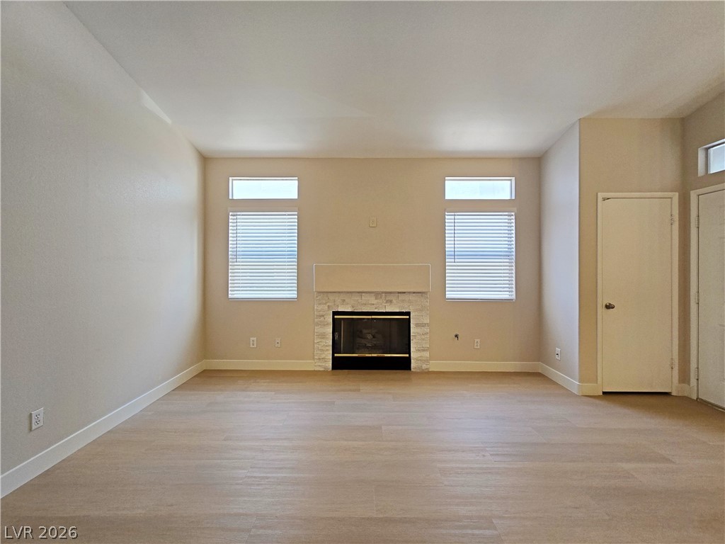 5370 Runningbrook Road Las Vegas, NV 89120 - Photo 14 of 30 A refined living space features a tiled fireplace and light wood-look flooring.