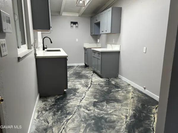 a room with a sink a window and cabinets
