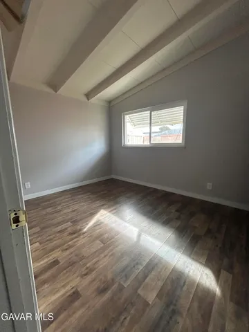en empty room with wooden floor and windows