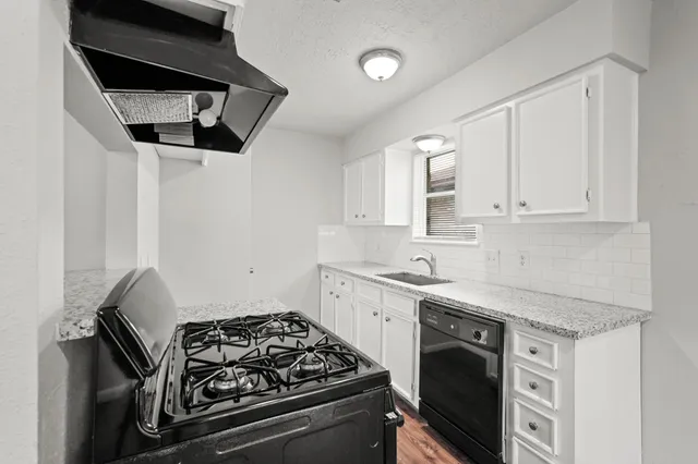 a kitchen with stainless steel appliances granite countertop white cabinets and a stove
