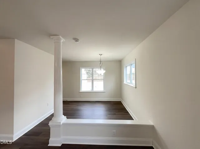 a room with wooden floor and white walls
