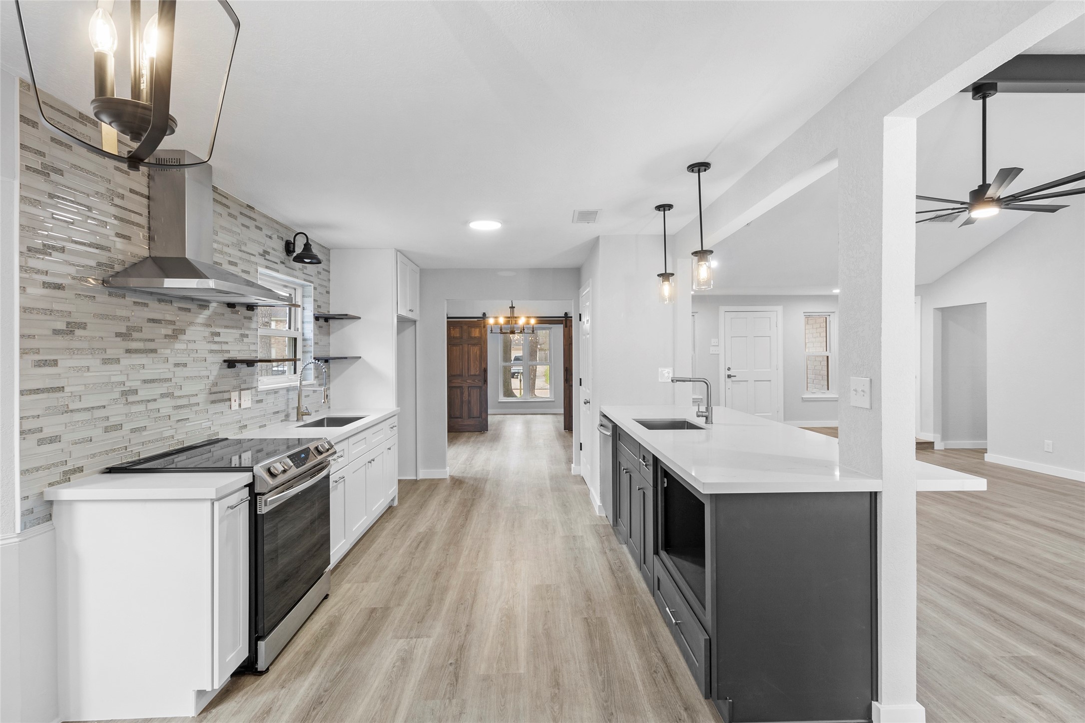 a large kitchen with stainless steel appliances granite countertop a lot of counter space and wooden floors