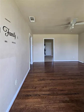 a view of an empty room with wooden floor