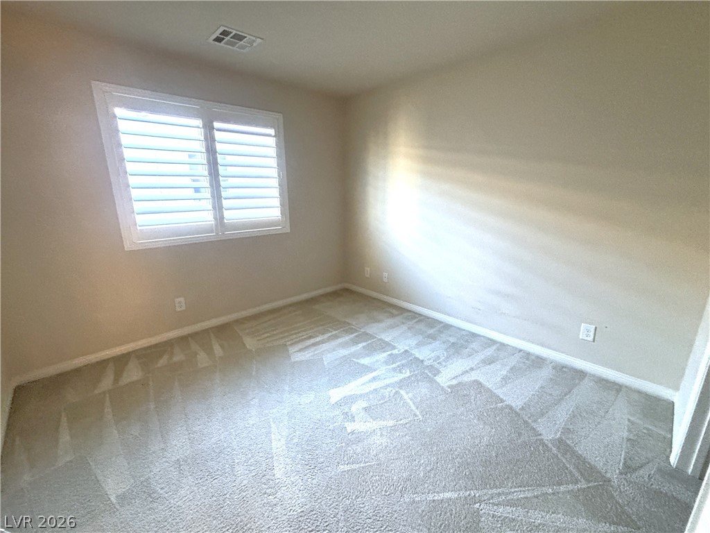 121 Elm Reed Avenue Las Vegas, NV 89113 - Photo 22 of 30 Well-lit room with fresh carpet and plantation shutters for adjustable light.