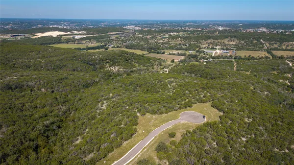an aerial view of residential houses with outdoor space and trees