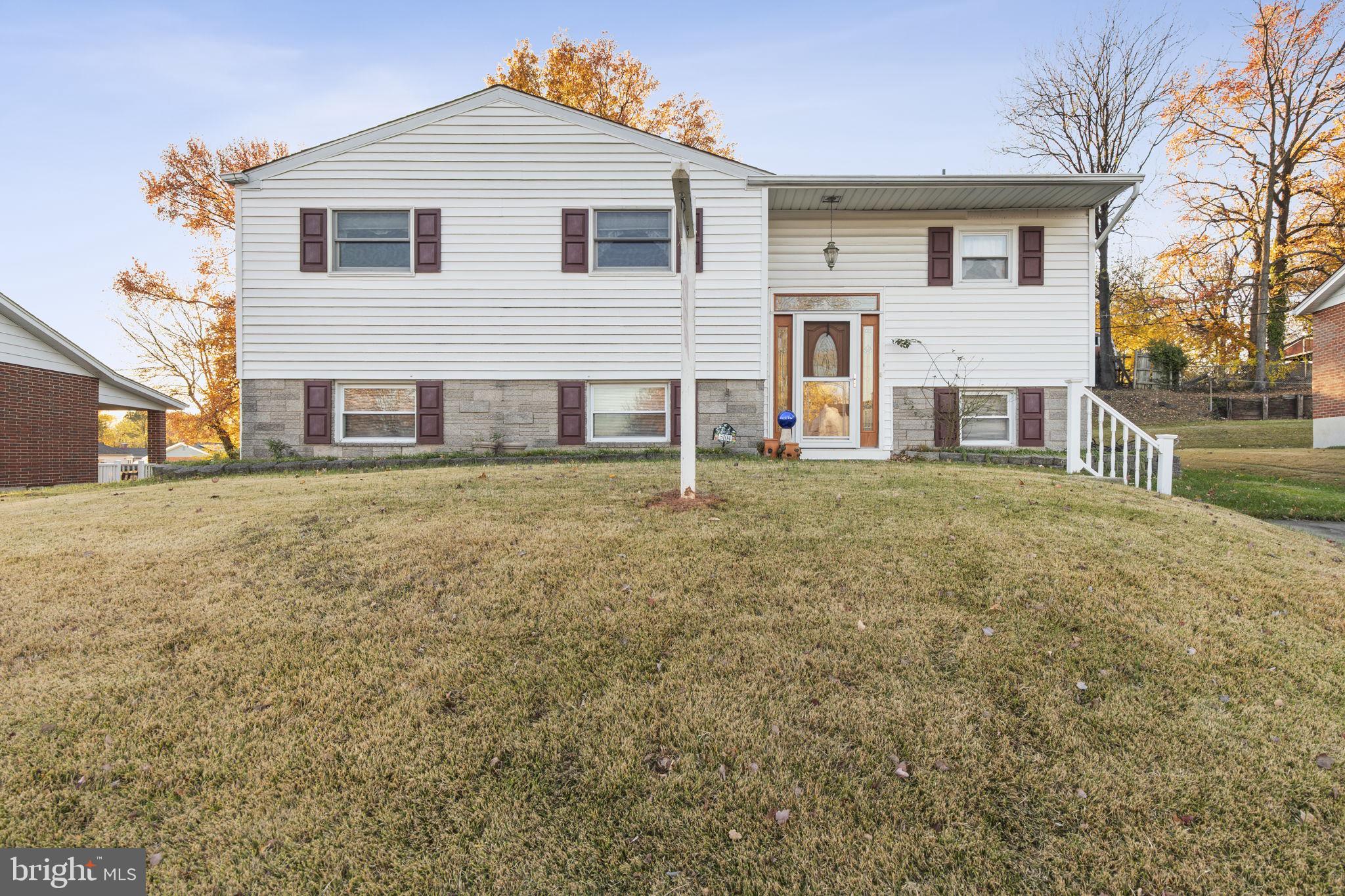 a front view of a house with a large tree