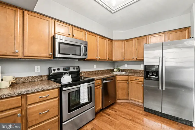 a kitchen with stainless steel appliances a stove a sink and a microwave