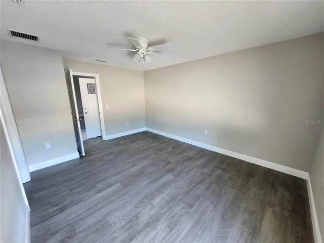 an empty room with wooden floor and closet