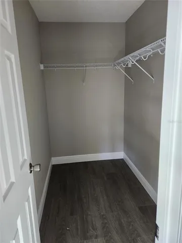 a view of walk in closet with wooden floor