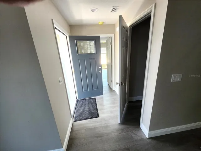 a view of a hallway with windows and closet