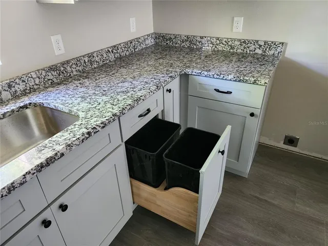 a kitchen with granite countertop a stove and a sink