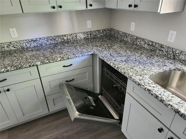 a kitchen with granite countertop a sink and a stove