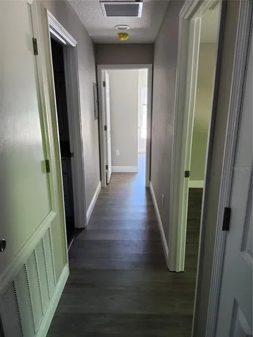a view of a hallway with wooden floor