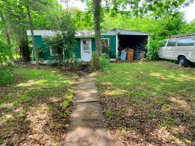 a view of a house with backyard and a tree