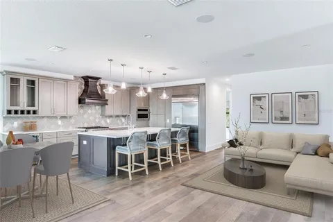 a living room with furniture a rug kitchen view and a window