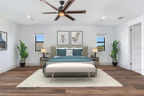 a bedroom with a large bed and a potted plant