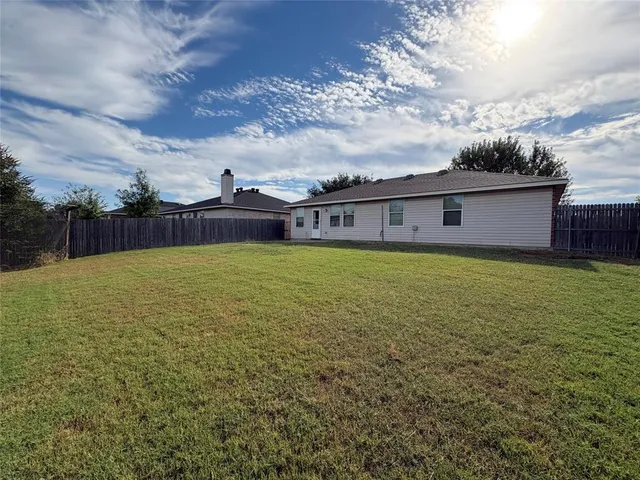wooden view of a lake with a big yard and large trees