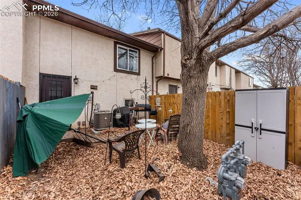 a view of a patio with table and chairs with wooden fence