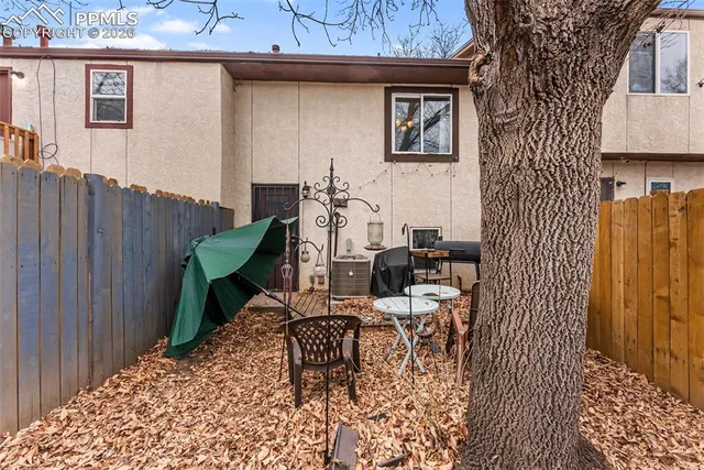 a backyard of a house with chairs and table and chairs