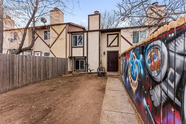 a view of a house with wooden fence