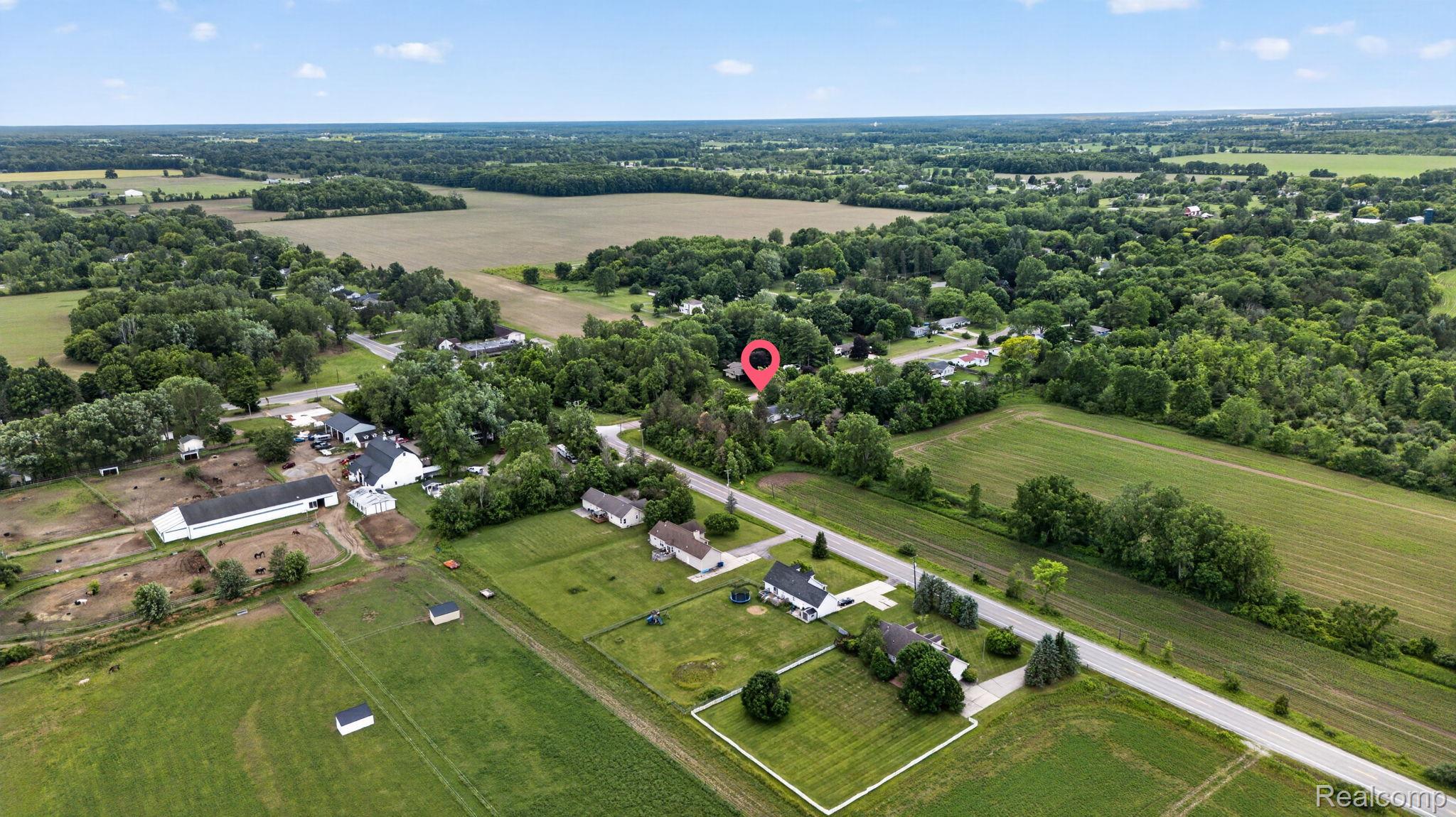 9288 Hilda Lane Flushing, MI 48433 - Photo 47 of 50 Expansive rural setting featuring a main residence, agricultural buildings, and surrounding green fields