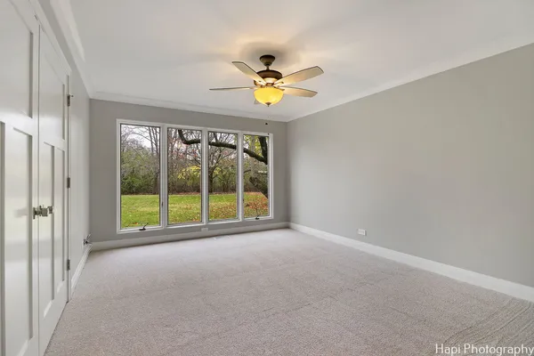 an empty room with closet and a ceiling fan