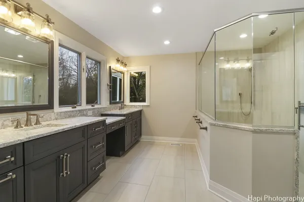 a spacious bathroom with a granite countertop sink mirror and shower