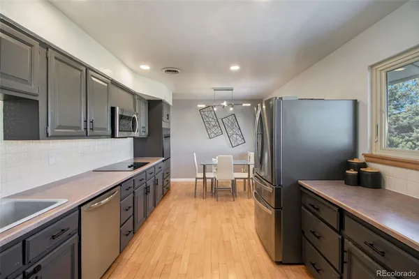 a kitchen with stainless steel appliances granite countertop a sink stove and refrigerator