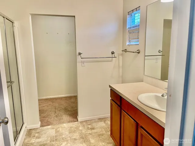a bathroom with a granite countertop sink a mirror and shower