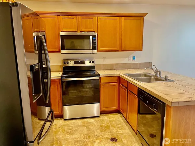 a kitchen with stainless steel appliances a stove a sink and a microwave