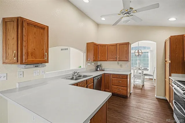 a kitchen with stainless steel appliances a sink cabinets and wooden floor