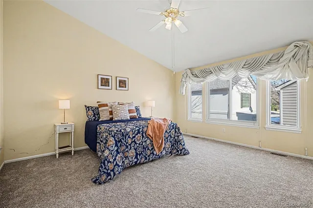 a bed sitting in a bedroom next to a window and a chandelier