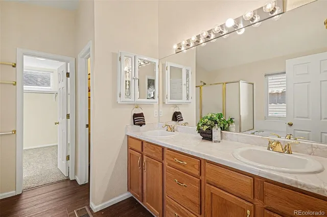 a bathroom with double vanity sinks a vanity two mirror and shower