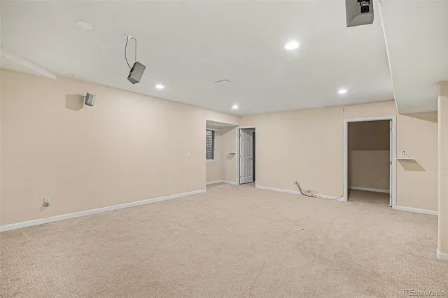 an empty room with ceiling fan and windows